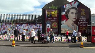 Des fleurs déposées devant un portrait d'Elizabeth II à Belfast (12/09/22)