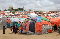 Somali children who fled drought-stricken areas stand by their makeshift shelters at a camp for the displaced on the outskirts of Mogadishu, Somalia Saturday, Sept. 3, 2022.