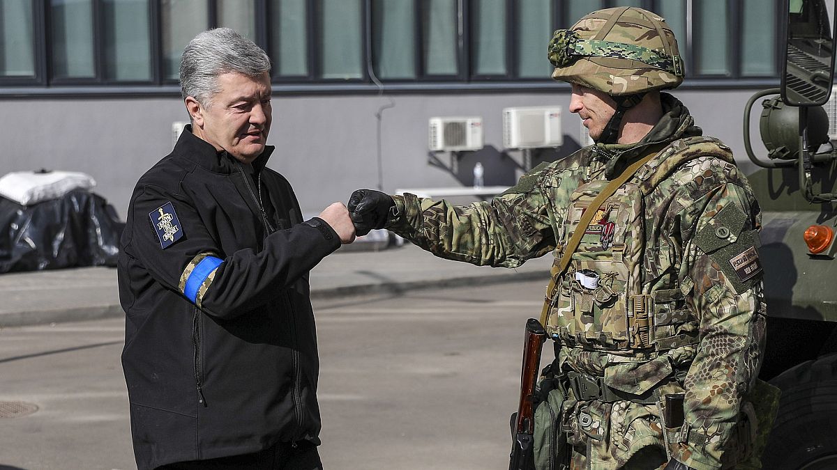 Petro Porosenko volt ukrán elnök egy ukrán katonát üdvözöl Kijevben 2022. március 18-án