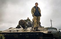 Soldado ucraniano em cima de um tanque numa parte libertada da região de Kharkiv