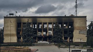 Украинский флаг над разрушенным зданием мэрии Изюма, Харьковская область