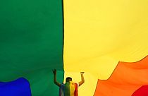 Un participante sostiene una gran bandera arcoíris durante la marcha anual del orgullo LGBT en Belgrado, Serbia, el sábado 18 de septiembre de 2021