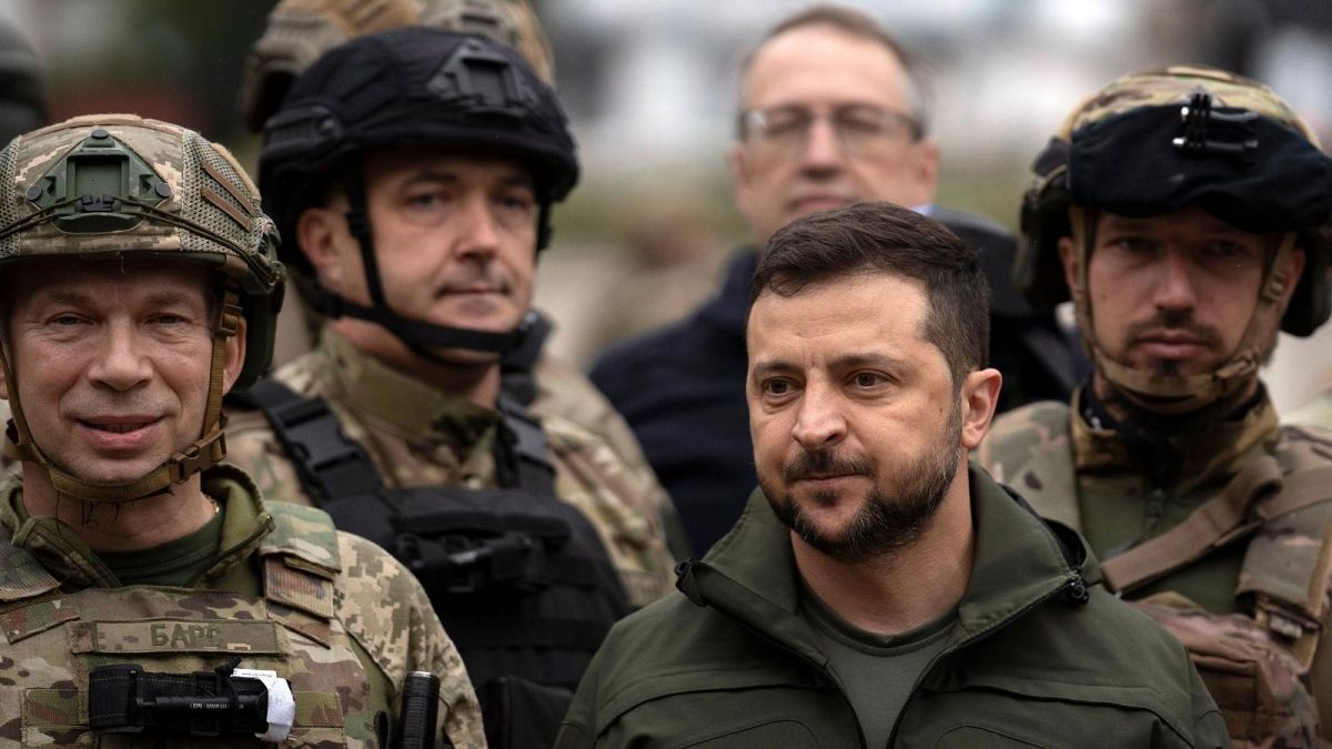 Ukrainian President Volodymyr Zelenskyy poses for a photo with soldiers after attending a national flag-raising ceremony in the freed Izium, Ukraine, Wednesday, Sept. 14, 2022