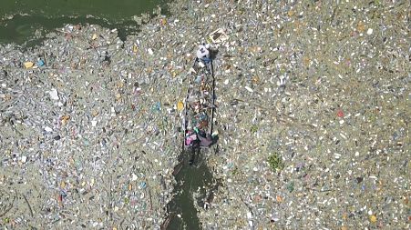 El Salvador's largest freshwater lake is covered in a thick blanket of plastic waste