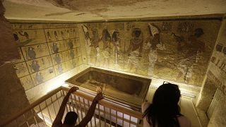 سياح ينظرون إلى قبر الفرعون المصري الشهير توت عنخ آمون، المعروض في علبة زجاجية بوادي الملوك. 2015/11/05