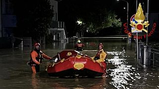 Rescue workers arrive on a dinghy boat on a flooded street after heavy rains hit the east coast of Marche region in Senigallia, Italy, September 16, 2022