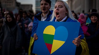 People take part in a protest against the Russian invasion of Ukraine at Independence Square at the Parliament Palace in Vilnius, Lithuania, Thursday, March 24, 2022