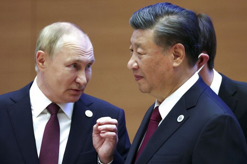 Russian President Vladimir Putin gestures while speaking to Chinese President Xi Jinping during the Shanghai Cooperation Organization (SCO) summit in Samarkand, September 2022