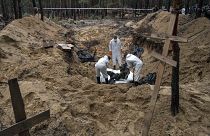 Des experts soulèvent un corps pendant une exhumation dans la zone récemment reprise d'Izioum, en Ukraine, vendredi 16 septembre 2022.