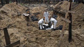 Des experts soulèvent un corps pendant une exhumation dans la zone récemment reprise d'Izioum, en Ukraine, vendredi 16 septembre 2022.