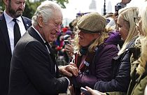 III. Károly brit király kezet fog egy II. Erzsébet ravatalához várakozóval 2022. szeptember 17-én