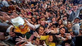 Cientos de jóvenes tienden la mano para conseguir cerveza gratis en una de las carpas de cerveza en la 187ª edición del Oktoberfest en Múnich, Alemania, el 17 de septiembre.