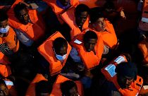 Migrants rescued by the Spanish NGO Open Arms in the Mediterranean sea huddle in a boat early Sunday, Sept. 18, 2022.