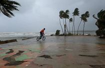 Un joven monta en bicicleta en la costa, mientras Fiona llega a República Dominicana 
