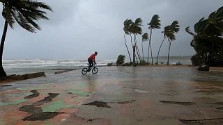 Un joven monta en bicicleta en la costa, mientras Fiona llega a República Dominicana 