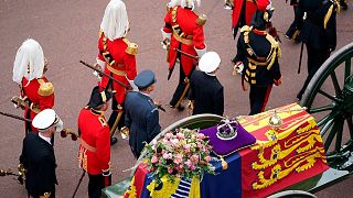 The State Gun Carriage carries the coffin of Queen Elizabeth II, draped in the Royal Standard with the Imperial State Crown and the Sovereign's orb and sceptre