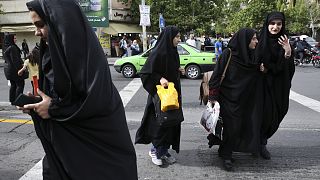 Iranian women wearing headscarves crossing a street in Tehran, Iran. Sunday, 22 April 2018.