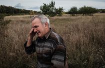Valeriy Balandiuk, who returned home four days ago, cries after burying his dog that died during the Russian occupation, in the retaken town of Tsupivka, Kharkiv region