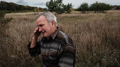 Valeriy Balandiuk, who returned home four days ago, cries after burying his dog that died during the Russian occupation, in the retaken town of Tsupivka, Kharkiv region