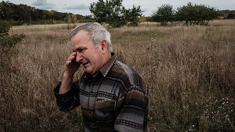Valeriy Balandiuk, who returned home four days ago, cries after burying his dog that died during the Russian occupation, in the retaken town of Tsupivka, Kharkiv region