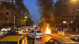 Égő motorbicikli egy teheráni tüntetésen