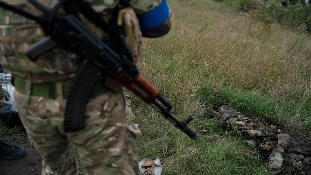 Soldado ucraniano junto ao cadáver de um compatriota na região de Kharkiv
