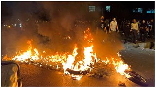 متظاهرون وسط طهران قرب دراجة نارية تابعة للشرطة تم حرقها احتجاجا على مقتل شابة إيرانية 19/09/2022