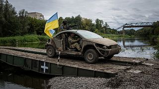 Ukrainian paratroopers drive on the vehicle with Ukrainian flag on the pontoon bridge across Siverskiy-Donets river in the recently retaken area of Izium, Ukraine, Wednesday, 