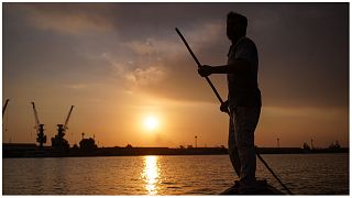 صياد عراقي على قاربه عند غروب الشمس في شط العرب