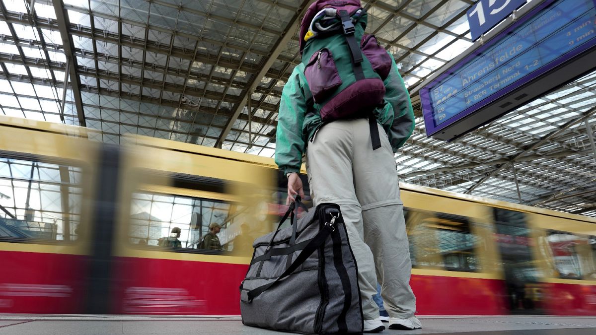 A traveller stands on a platform as a suburban train arrives at the main train station in Berlin, Germany, Wednesday, June 1, 2022