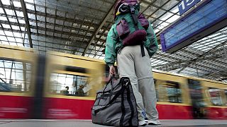A traveller stands on a platform as a suburban train arrives at the main train station in Berlin, Germany, Wednesday, June 1, 2022
