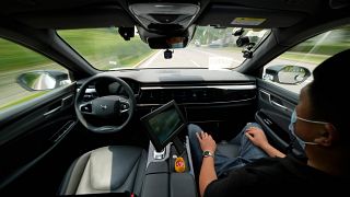 A technician monitors the self-driving taxi developed by tech giant Baidu Inc. on June 14, 2022, in Beijing.