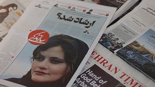 A newspaper with a cover picture of Mahsa Amini