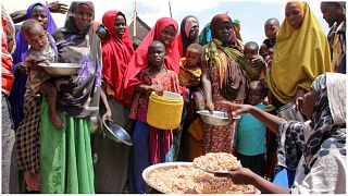 صورة من الارشيف-يتلقى صوماليون نازحون بسبب الجفاف، توزيعات غذائية في مخيمات مؤقتة في منطقة تابيلا في ضواحي مقديشو، الصومال