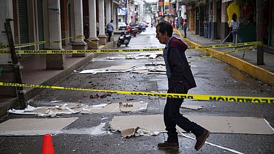 A resident walks through a street cordoned off amid debris from the previous day's earthquake in Coalcoman.