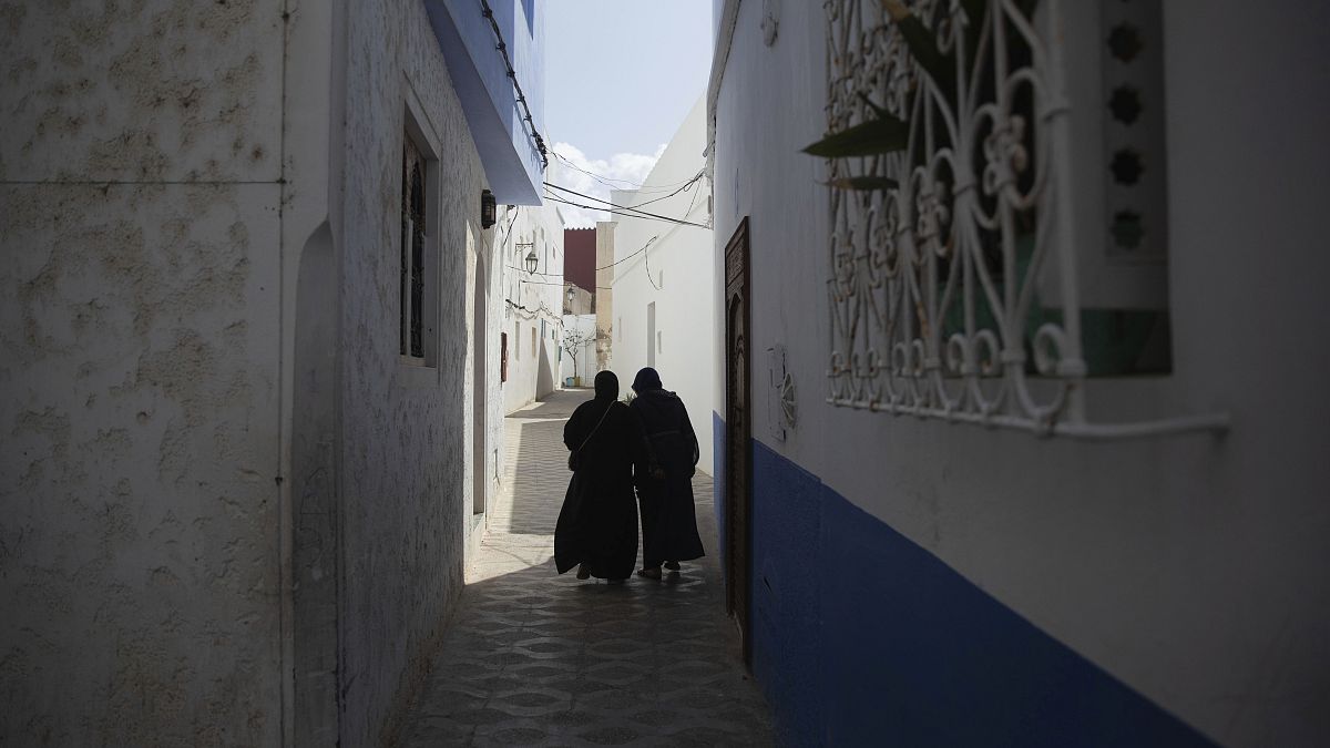 امرأتان تسيران في أزقة مدينة أصيلة، شمال المغرب
