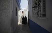 امرأتان تسيران في أزقة مدينة أصيلة، شمال المغرب