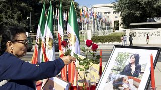 Цветы у портрета Махсы Амини у европейской штаб-квартиры ООН в Женеве