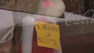 Manequim pendurado num bar de Itália, com o anúncio da fatura da eletricidade