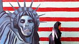 A veiled Iranian woman walks past an anti U.S painting on the wall of the former U.S Embassy in Tehran, Saturday, July 2, 2005.