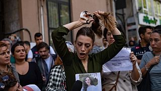 Nasibe Samsaei, an Iranian woman living in Turkey, cuts her ponytail off during a protest outside the Iranian consulate in Istanbul on September 21, 2022.