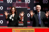 Michael G. Wilson and Barbara Broccoli have their hands imprinted during a ceremony at the TCL Chinese Theatre