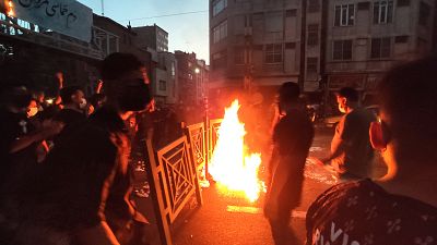 Los manifestantes hacen fuego y bloquean una calle del centro de Teherán, Irán, el 23 de septiembre de 2022. 
