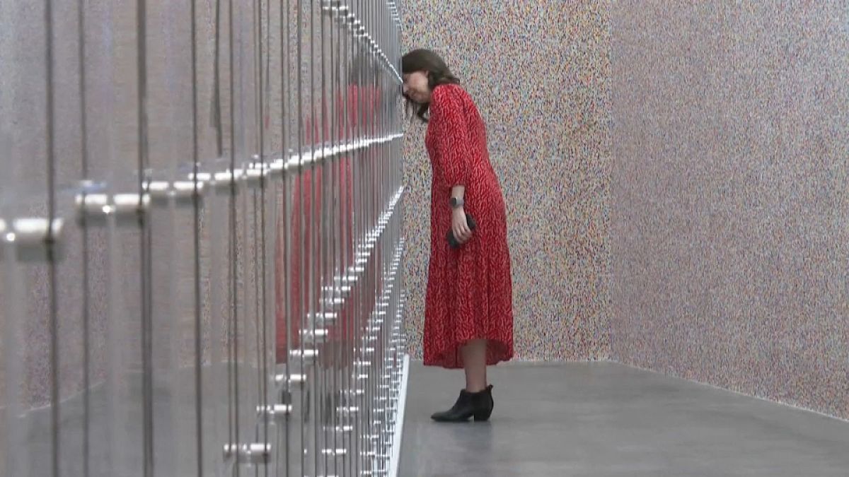 Woman posing during the preview of Damien Hirst's exhibition 'The Currency'