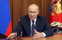 Russian President Vladimir Putin gestures as he addresses the nation