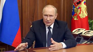 Russian President Vladimir Putin gestures as he addresses the nation