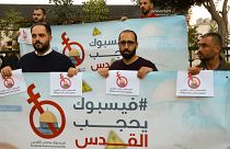 نشطاء وصحفيون فلسطينيون يحملون لافتات احتجاجا على رقابة فيسبوك للمحتوى الفلسطيني، في الخليل الضفة الغربية.