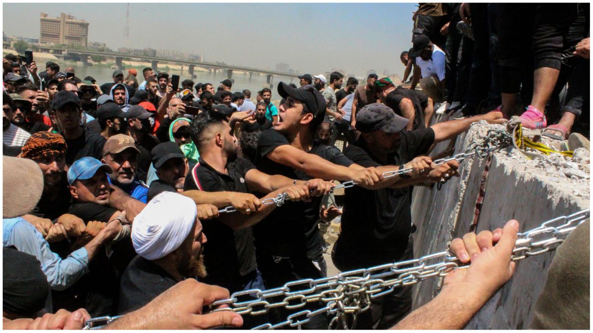 محتجون يحاولون اسقاط الكتل الخرسانية المحيطة بالمنطقة الخضراء وسط بغداد - 30/07/2022