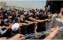 محتجون يحاولون اسقاط الكتل الخرسانية المحيطة بالمنطقة الخضراء وسط بغداد - 30/07/2022