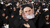 Una manifestante progubernamental sostiene un póster del difunto fundador de la revolución iraní, el ayatolá Jomeini en Teherán, Irán, el viernes 23 de septiembre de 2022.
